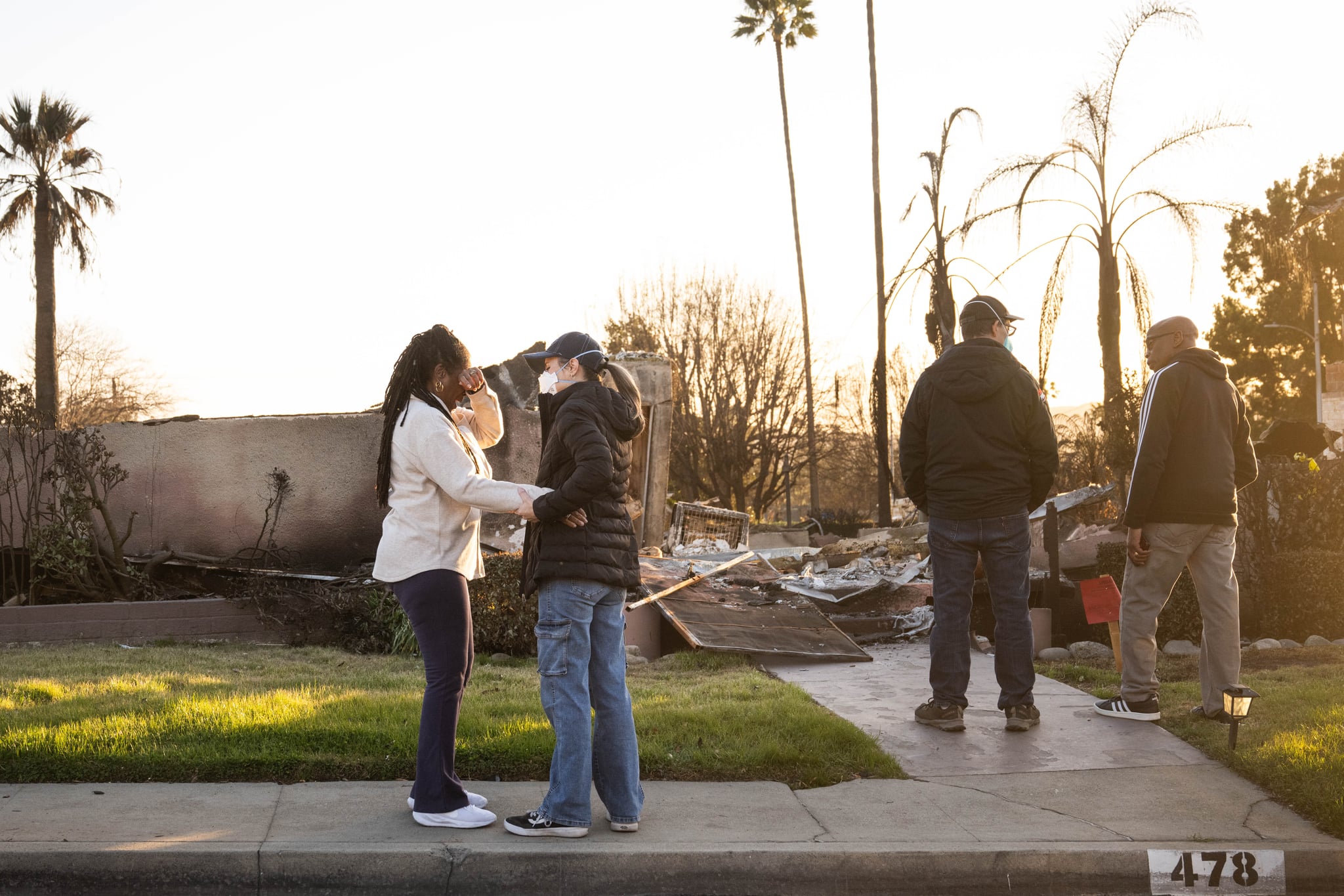 Altadena, CA - January 20:Dina Villani comforts Elaine Emerson as she returns to her Altadena neighborhood and finds her home in ashes on Monday, January 20, 2025 as their husbands Pete Villani and Jarvis Emerson talk. The neighbors said they use to wave before the Eaton fire and now its hugs and tears. (Photo by Sarah Reingewirtz/MediaNews Group/Los Angeles Daily News via Getty Images)