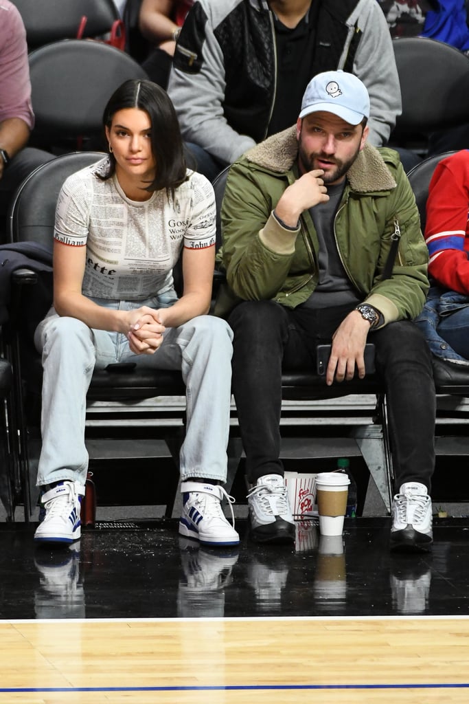 Kendall attended an LA Clippers basketball game in these blue striped Adidas high tops. She hung courtside in a newspaper print tee and baggy jeans.