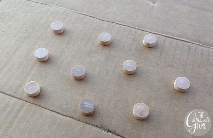 At the same time, I set a group of my little wooden furniture plugs out on a piece of cardboard. They received a coat of gold spray paint and then a few subsequent coats of dark bronze spray paint. This was due to me changing my mind, but I do think the gold underneath the bronze gave them kind of a cool effect. If you have both colors of spray paint on hand, why not, right?
