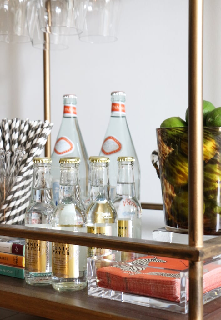 No detail is overlooked on the bar cart, from an acrylic tray holding colorful cocktail napkins to a bundle of striped straws.