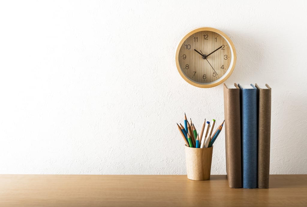 Desk clock and books on office desk table. With copy space. Shot with ISO64.