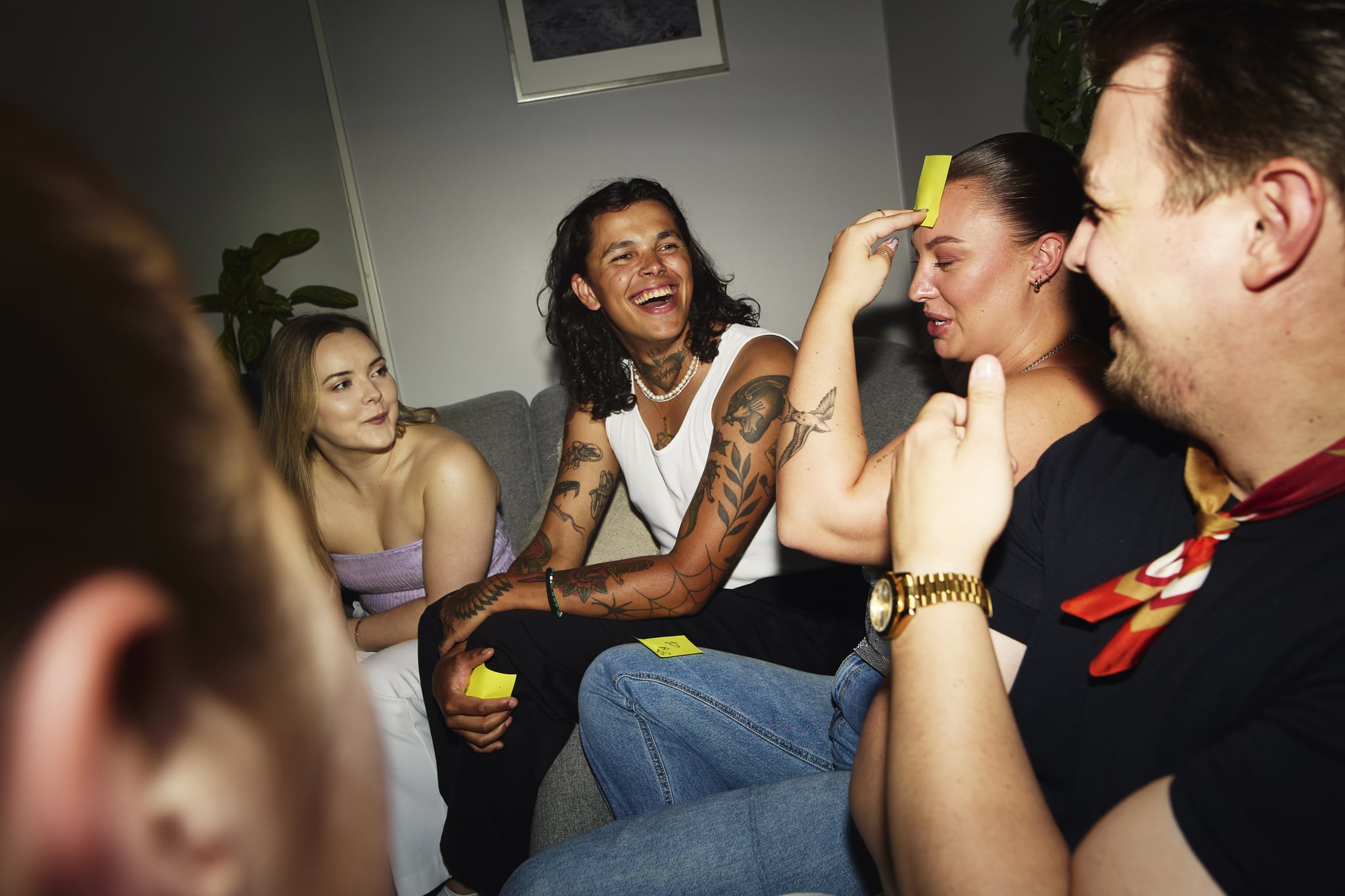 Group of friends playing guessing game during a chaos party at home
