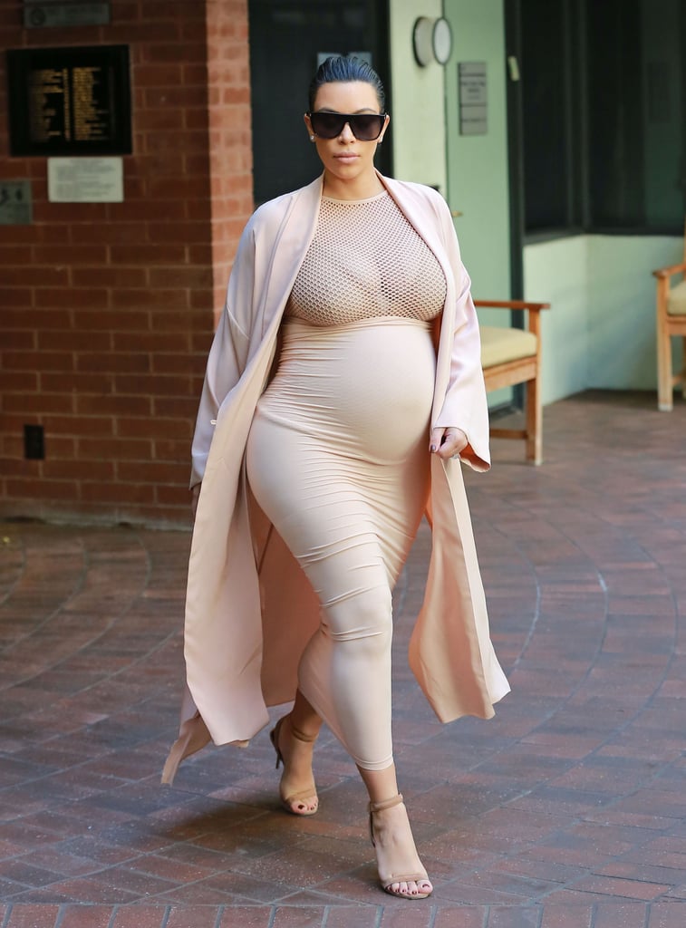 Kim stuck to her signature neutrals in a high-waisted body-con skirt that she met with a racy mesh top. She added a duster coat and completed her look with taupe ankle-strap sandals.