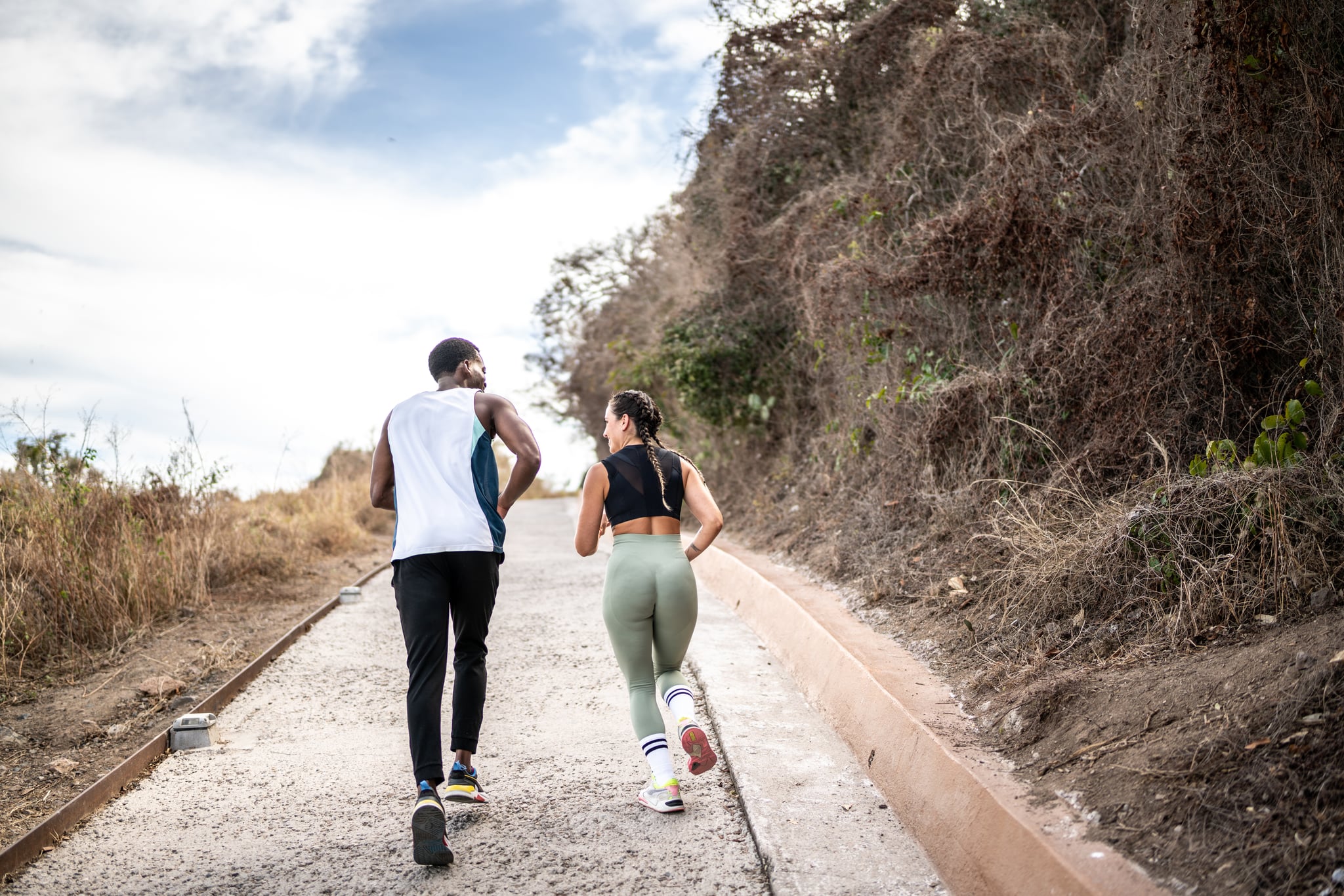 Couple running together outdoors.