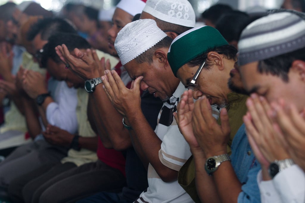 Men in Kuala Lumpur, Malaysia, prayed for the missing passengers on Friday.