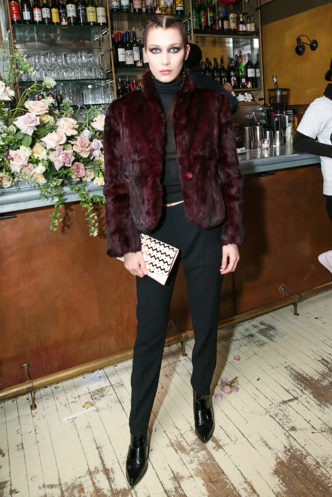 Bella, who showed off a similar smoky eye to Gigi, kept things dark in black separates, leather loafers, and an oxblood furry coat. Our favorite touch? Her playful braids mimicked the pattern on her own clutch.