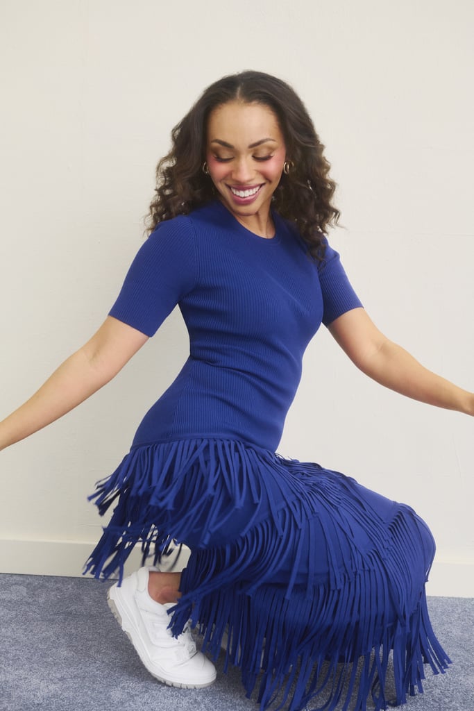 Simon Miller Zaza Dress ($296, originally $395). New Balance BB550 Sneakers ($110). Jennifer Fisher Triple Lilly Huggie Earrings ($400).
A true lover of movement, Delanie Smith made this blue fringe dress come alive, twirling and dancing on set with that feel-good energy we all adore.
Get The Look: Hyancith House Navy Sequin Fringe Stevie Midi Dress ($188). Amazon Essentials Split Hoops ($13). Pattern REPAIR360 Leave-In Foam ($49).