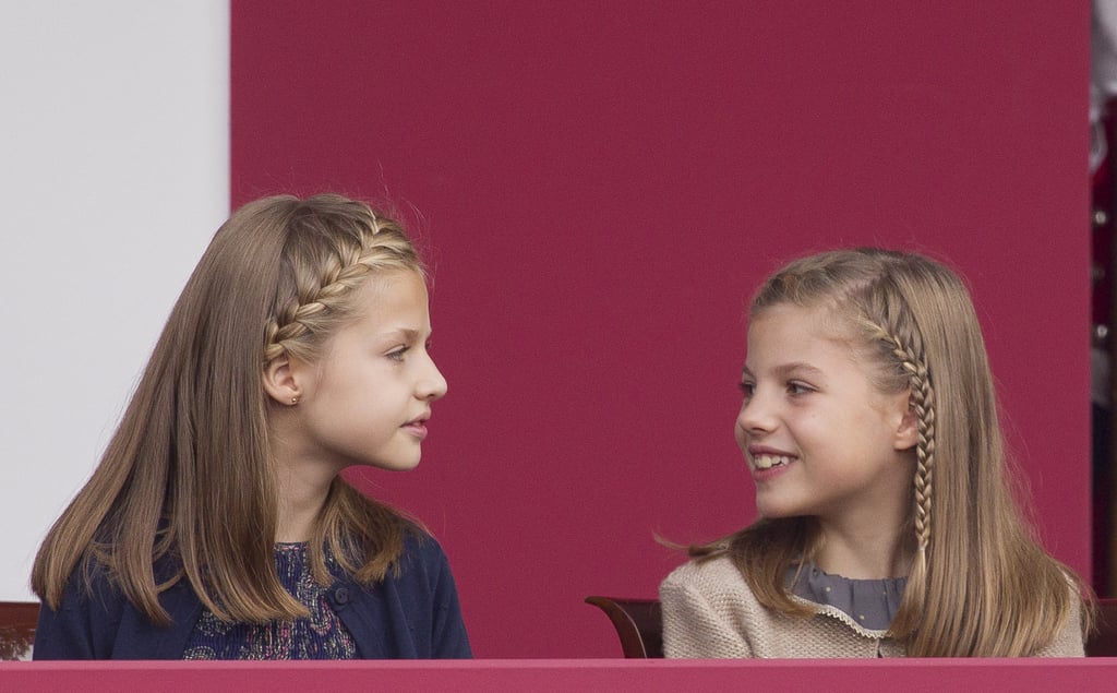 Princess Leonor and Infanta Sofía keep each other entertained during the National Day Military Parade.