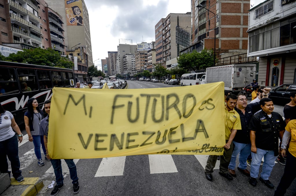 Protesters hold a sign that says "My future is Venezuela."