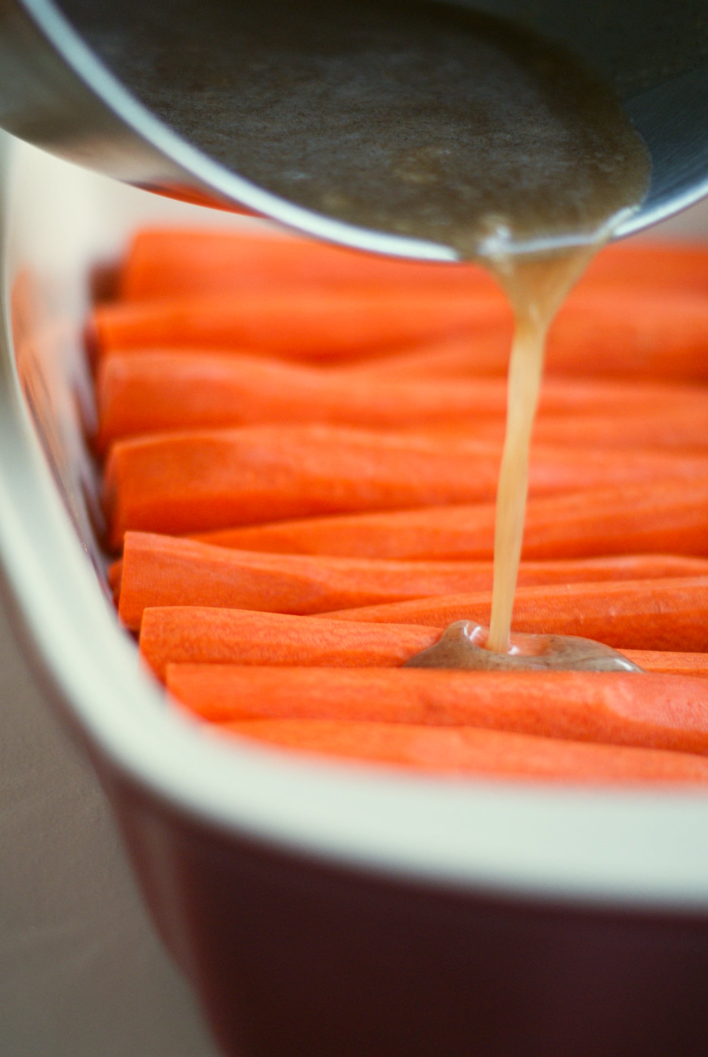 Cinnamon Butter Baked Carrots recipe: covering carrots in cinnamon butter sauce