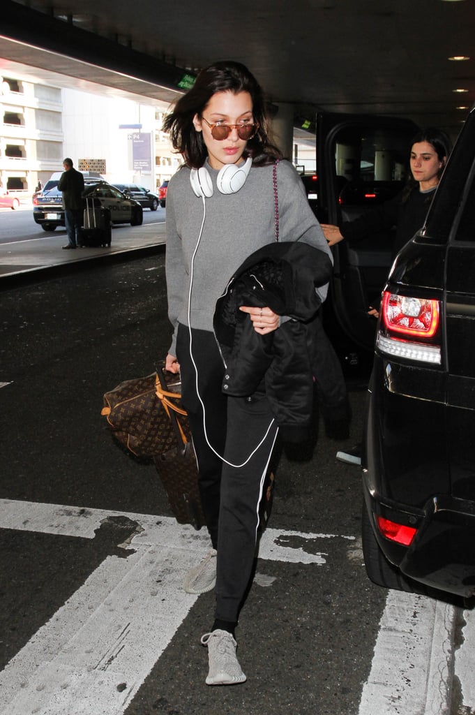 Playing up the gray shade of her sweatshirt with Yeezy sneakers and toting her Louis Vuitton luggage at her side.