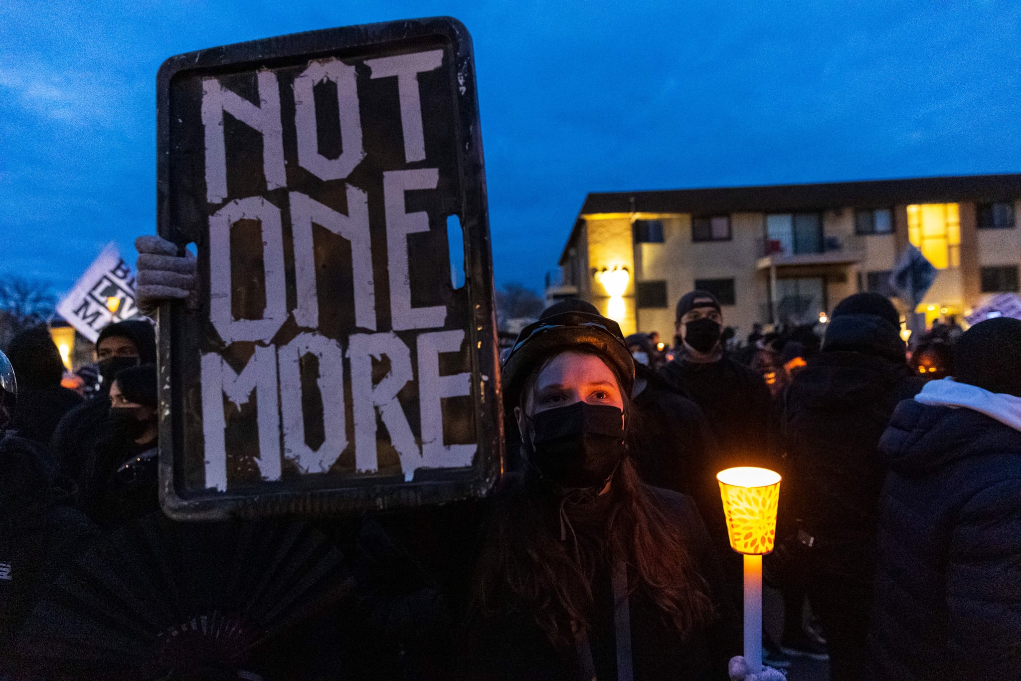 TOPSHOT - Demonstrators hold candles and signs as they protest peacefully ahead of the 10pm curfew, in front of the Brooklyn Central Police Station in Brooklyn Centre, Minnesota on April 15, 2021. - Kim Potter, the policewoman who shot dead Daunte Wright in a Minneapolis suburb after appearing to mistake her gun for her Taser, was arrested on Wednesday on manslaughter charges. Minneapolis has been roiled by nightly violent protests after Potter's shooting of Wright in his car on Sunday. (Photo by Kerem Yucel / AFP) (Photo by KEREM YUCEL/AFP via Getty Images)