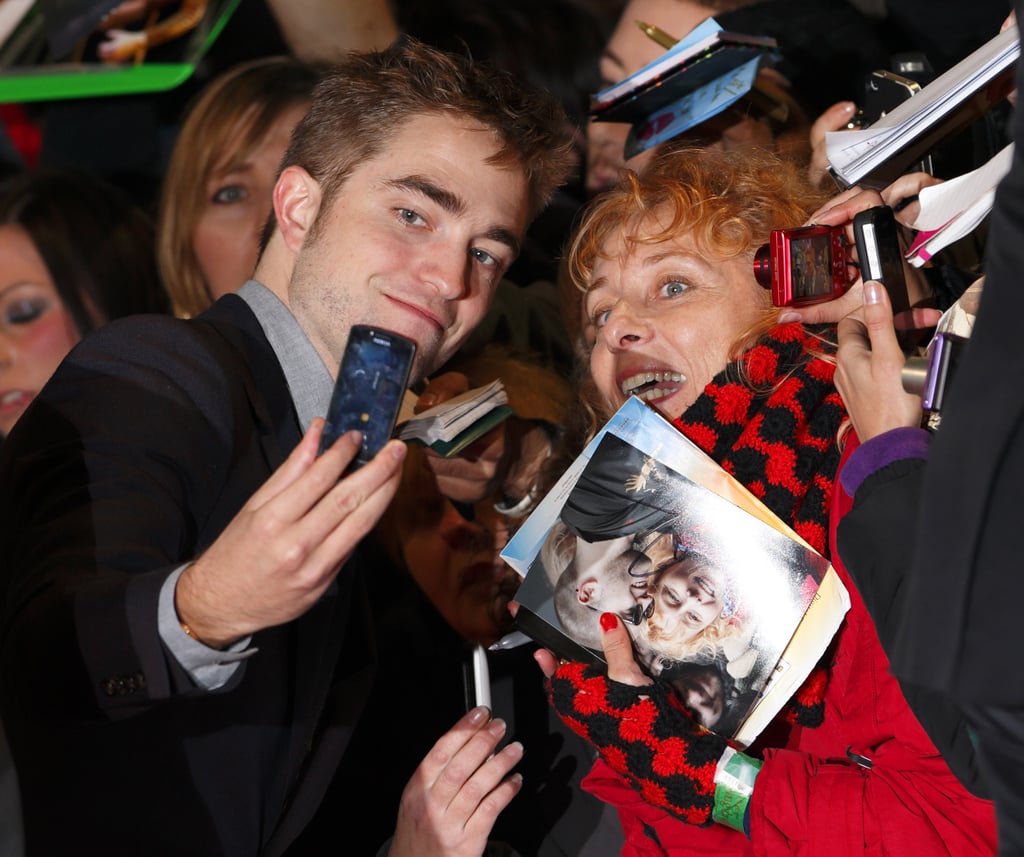 Robert Pattinson smiled with a fan in November 2012 before heading into the London premiere of Breaking Dawn Part 2.