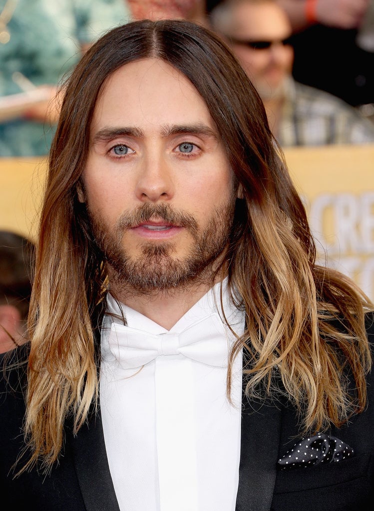 POPSUGAR: Before the Oscars, we polled our readers to see how Jared should wear his hair. The options were beach waves, ponytail bun, or the wet look. The results: 45 percent picked waves, 42 percent picked an updo, and 13 percent said the wet look. Our readers had it right! So how did you and Jared reach this monumental decision?
Chase Kusero: We've definitely been experimental, and that's been a key to his hair looking great. He likes to have his style unique to the moment. We did ponytail bun for Golden Globes, and if we did it again, it would seem [old]. We did the Indie Spirit Awards the night before, so he started with product in his hair, and then he slept on it. When he put his jacket on, we knew it had to be down for an iconic vibe. We knew that was it. 
PS: What are some tips you can offer our readers to get Jared's undone beach waves at home?
CK: We did subtle things, and it just worked. Yesterday was a big day for him, so his hair was kind of an afterthought. Washing the hair less is the key. Using some sort of wave-enhancing shampoo will add more moisture. That has been the key: moisturizing the hair allows it to hang well, have shine, and separate. The more moist the hair is, the more it can wave. Use a flat iron to bend 10 pieces, and it will give it that separation and make it feel undone. But we never use a curling iron or anything on Jared, or it will look too much like glam waves. Straight ends are also the key. Don't go all the way down with the hair iron to keep ends straight. It will make it look more disheveled.
PS: You have said that he doesn't and will never wear extensions. What are some natural tips for growing hair long? Does he get routine trims or eat certain foods? We heard he is a vegan.
CK: In the case of a female client, trimming is more of a necessity. When we started the process of growing out his hair, he left it in my hands. So we wanted it to get to a certain point so it doesn't look cut. Trimming it to make it grow is a myth. Yes you need to cut off dead ends, but doing less is better. Not doing color as often, getting less haircuts, washing it even less are all good for the growing process.