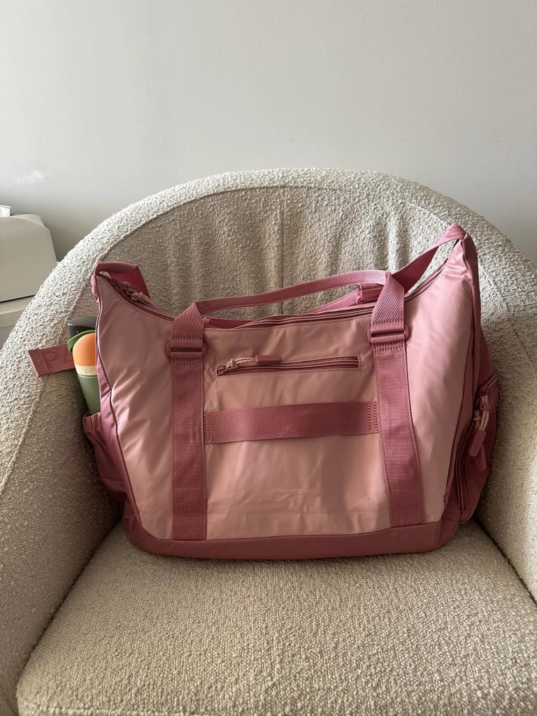 Calpak Fit Gym Bag in Tea Rose ($155)
This stylish gym bag from Calpak is just as functional as it is fashionable. It features several specialized compartments to help keep your workout gear organized (sneakers included). Read our Calpak Fit Gym Bag review for more.
Pros: Multiple compartments including a ventilated shoe pocket, has yoga mat straps and bottle holders
Cons: Higher price point compared to other options
Material: Not specified
Dimensions: 19.25" x 12.75" x 8"
Colorways: Three
Who It's Best For: Gym-goers and travelers looking for a highly-organized and stylish bag
Extras: Ventilated shoe pocket built into the side of the bag, yoga mat straps, water bottle holder with bungee
Editor Quote: "The side pocket designed to carry your shoes has a vent (to help your sweaty shoes dry faster) and extends into the bag instead of under or out. I prefer this as shoe compartments on the bottom of bags seem smart, but I've found they create a bulky and uneven bottom that makes it hard to set your bag down. Calpak's lets you 'pack' your shoes in the main compartment, while still keeping them hygienically separate from your clothes and accessories." – Mirel Zaman, former health and fitness content director