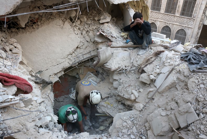 Syrian civil defense volunteers, the White Helmets, search for victims in Aleppo after an airstrike.