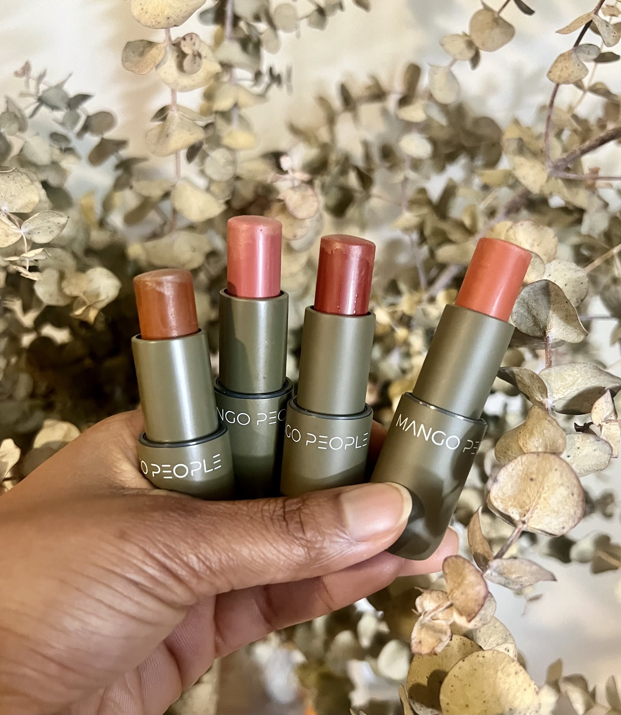 Woman holding the Mango People's Mango Cream Blush & Lip Multisticks.