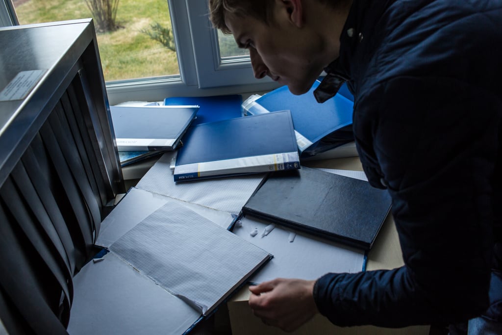 A man looked through record books in one of the security booths on the estate.