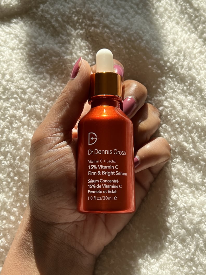 Woman holding the Dr. Dennis Gross Skincare Vitamin C Lactic 15% Firm and Bright Serum.
