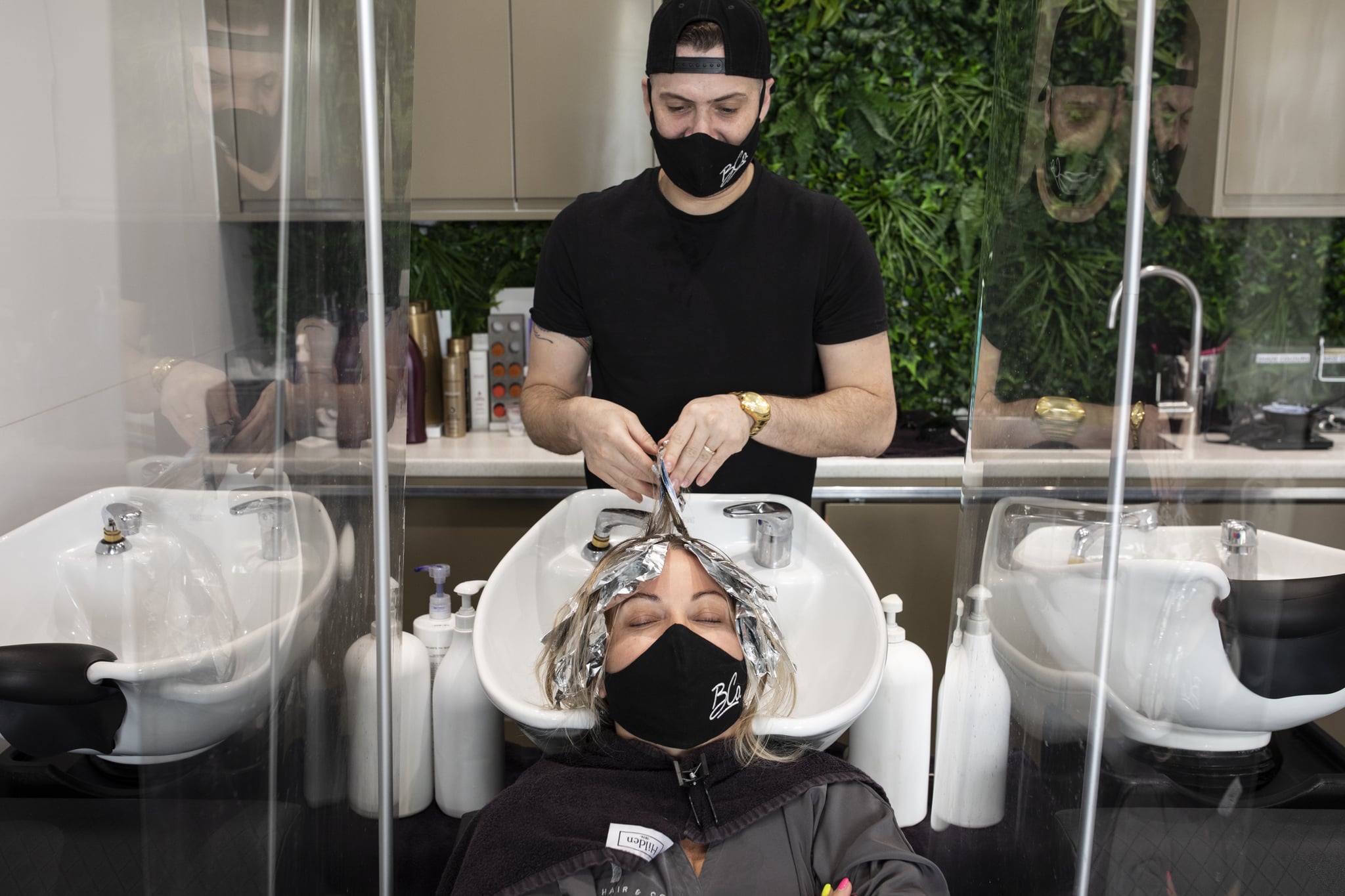 LONDON, ENGLAND - JULY 13: A customer wears a face mask while having her hair washed at a salon in Marylebone on July 13, 2020 in London, England. Nail salons, tattoo parlors and spas are among the businesses allowed to reopen today in England as the government eases the restrictions meant to curb the spread of Covid-19. (Photo by Dan Kitwood/Getty Images)