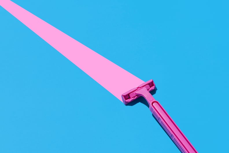 Elevated view of pink razor blade on a blue background