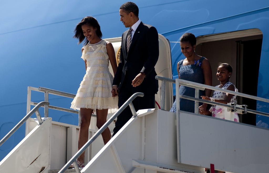 Wearing a white tiered dress adorned with bows.
