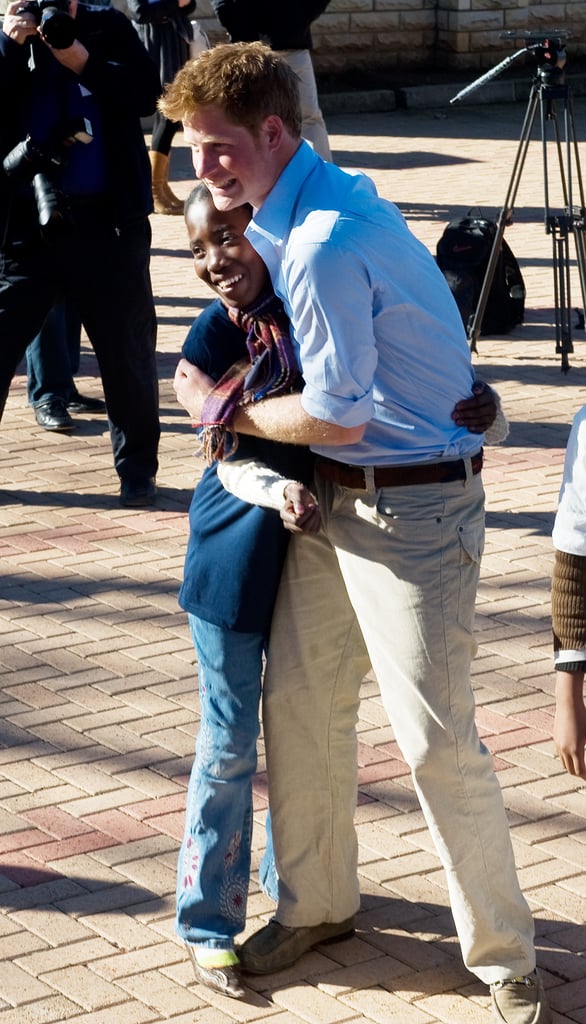 Harry hugged a young girl at the Mamohato Network Club at King Letsie's Palace in 2010.