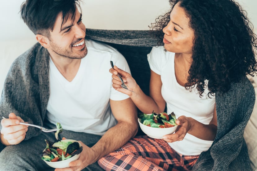 Beautiful Couple in love eating salad together