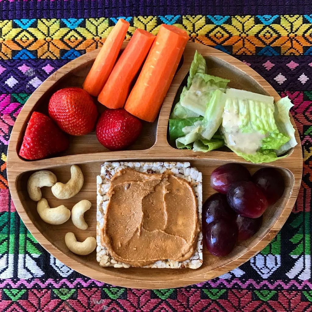 "Lunch: iceberg lettuce with Annies Homegrown goddess dressing (our munchkin loves salad because of this dressing), sliced purple grapes, red rice & quinoa cakes with nut butter, raw cashews, strawberries, and carrots."