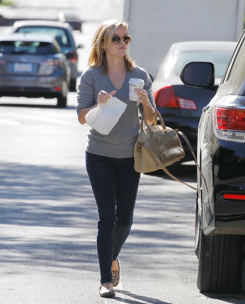 The typically casual Reese Witherspoon chose to accessorize her jeans and sweater combo with a beige bag.