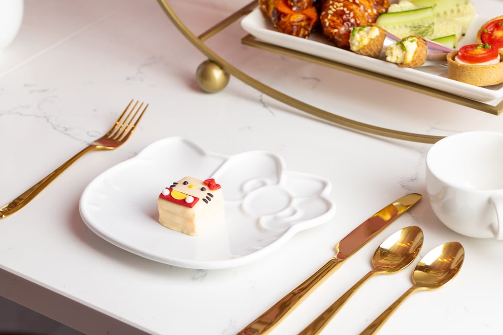 The table is set with Hello Kitty plates and gold flatware.
