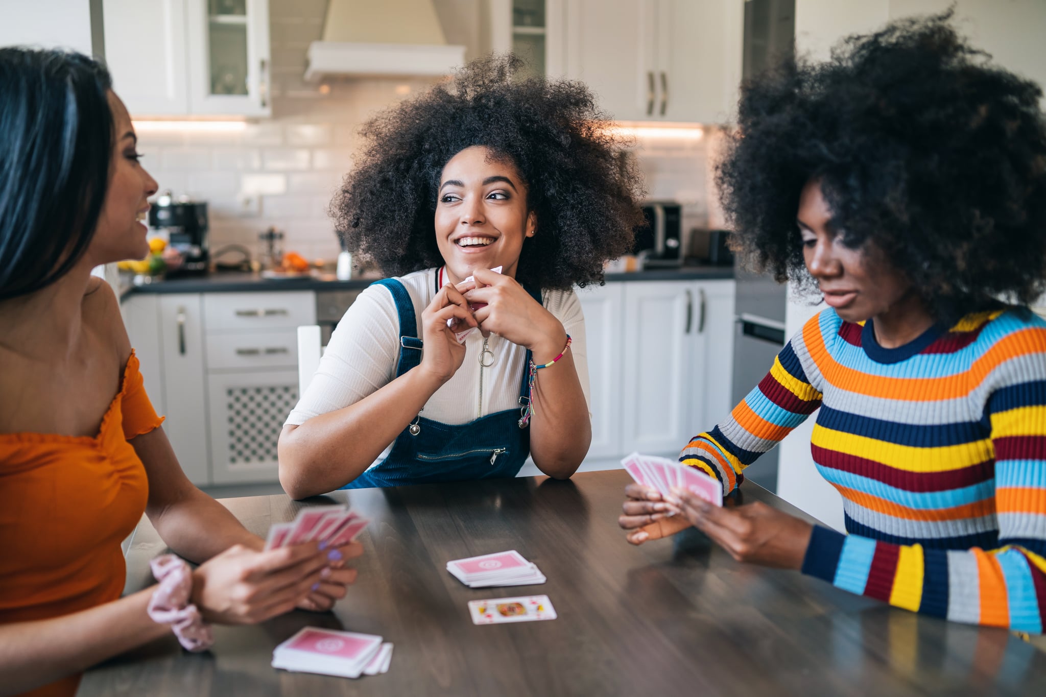 Three girls at home playing cards