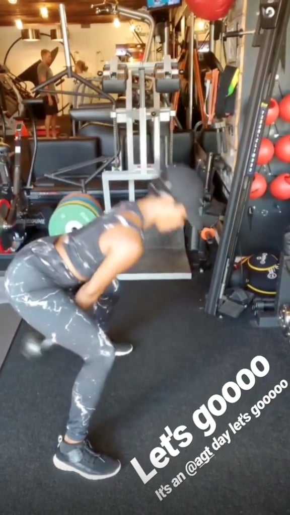 With her legs spread apart and both hands on the kettlebell, she swung the weight between her legs . . .