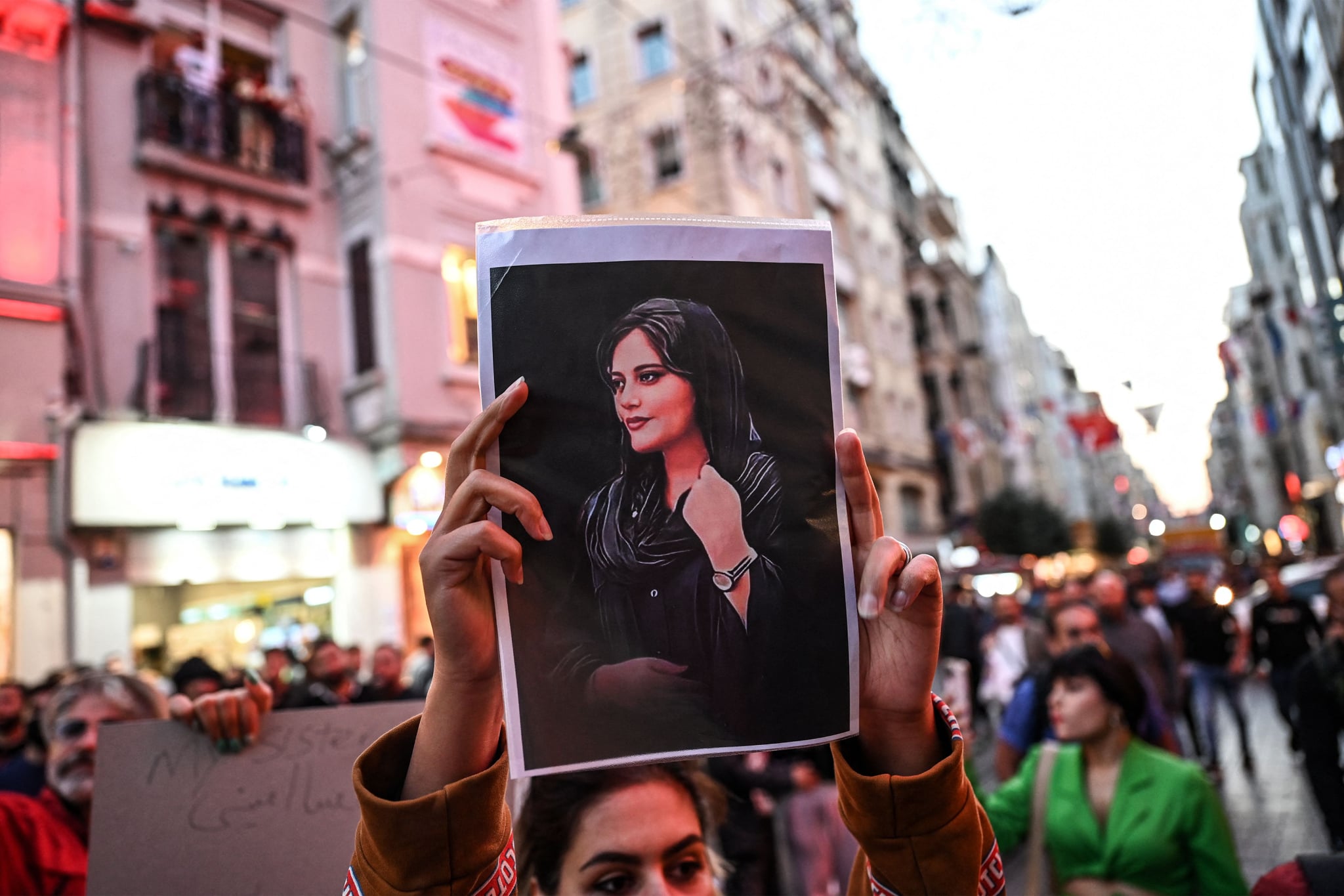 A protester holds a portrait of Mahsa Amini  during a demonstration in support of Amini, a young Iranian woman who died after being arrested in Tehran by the Islamic Republic's morality police, on Istiklal avenue in Istanbul on September 20, 2022. - Amini, 22, was on a visit with her family to the Iranian capital when she was detained on September 13 by the police unit responsible for enforcing Iran's strict dress code for women, including the wearing of the headscarf in public. She was declared dead on September 16 by state television after having spent three days in a coma. (Photo by Ozan KOSE / AFP) (Photo by OZAN KOSE/AFP via Getty Images)