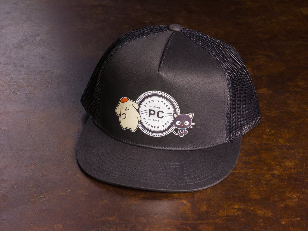 The limited edition Plan Check Kitchen + Bar Pompompurin and Chococat hat that comes with the meal.