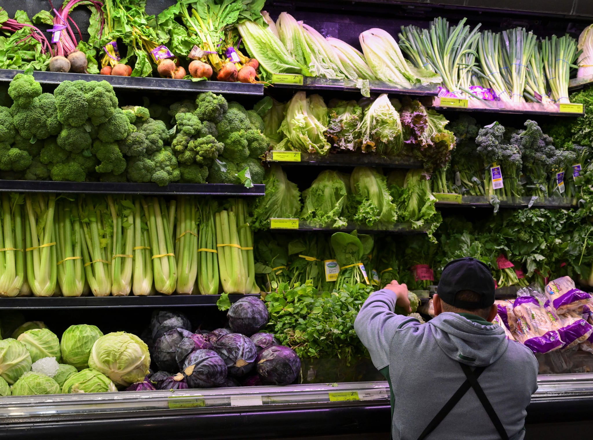 A produce worker stocks shelves near romaine lettuce (top shelf centre) at a supermarket in Washington, DC on November 20, 2018. - US health officials warned consumers not to eat any romaine lettuce and to throw away any they might have in their homes, citing an outbreak of E. coli poisoning. The Centres for Disease Control and Prevention (CDC) issued the warning against all Romaine lettuce just two days before the Thanksgiving holiday, when American families gather and feast together. (Photo by Andrew CABALLERO-REYNOLDS / AFP)        (Photo credit should read ANDREW CABALLERO-REYNOLDS/AFP/Getty Images)