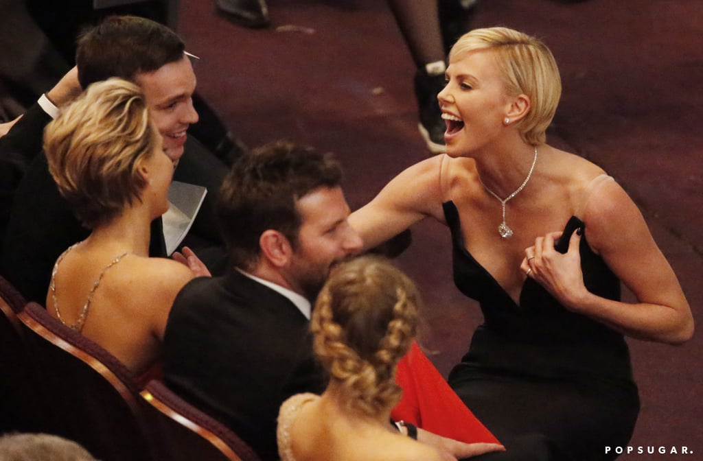 Charlize Theron cracked up while chatting with Jennifer Lawrence and her boyfriend, Nicholas Hoult, in the front row.