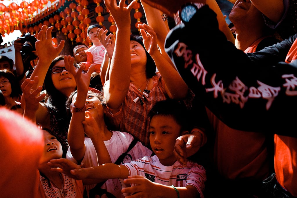 People grabbed sweets thrown by performers during the parade in Kuala Lumpur, Malaysia.