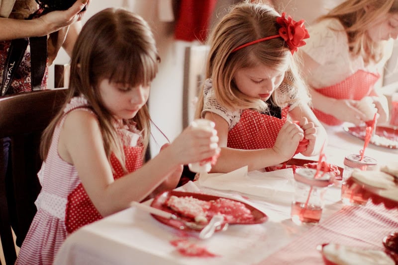 The girls wore red aprons to keep from getting messy during the fun cookie decorating. 
Source: Jenny Cookies