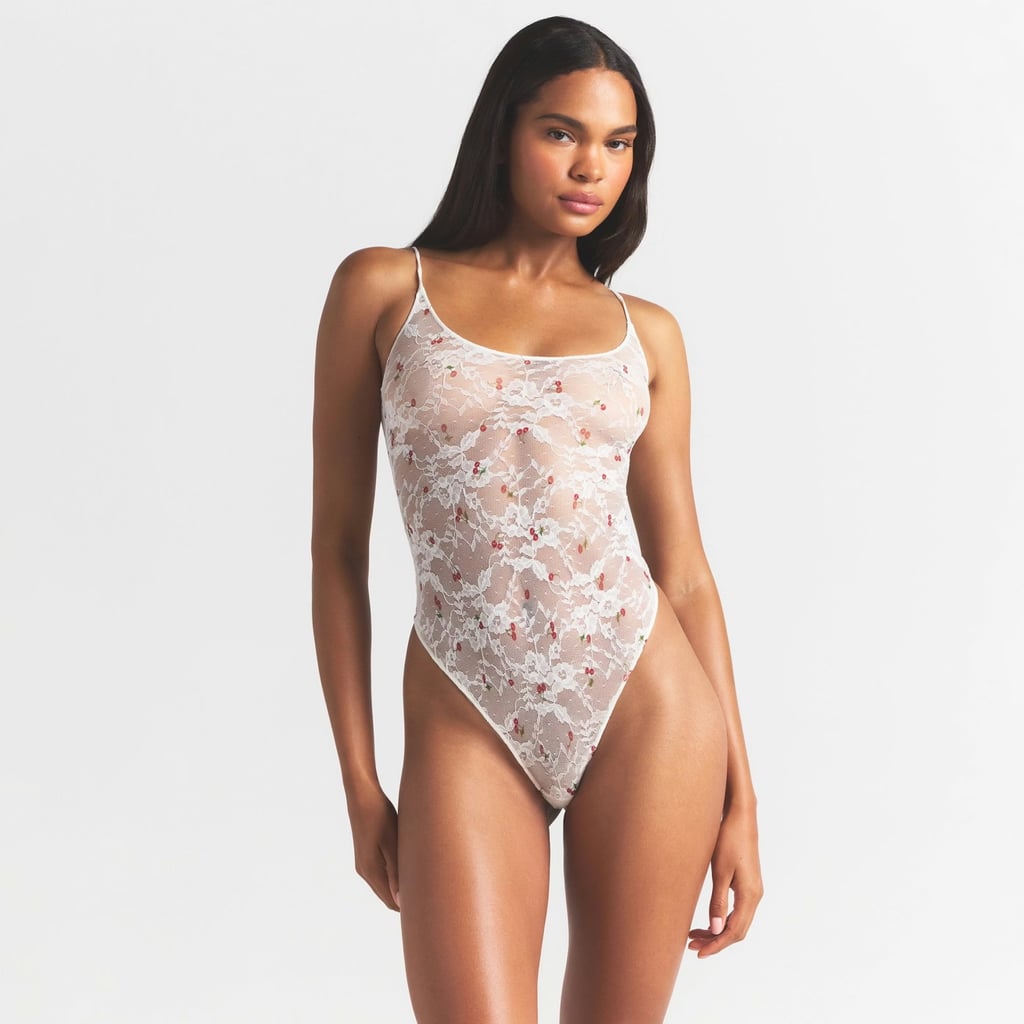 Skims Stretch Lace Scoop Neck Bodysuit ($68)
Whether you wear this bodysuit on its own or layer it under your clothes or pajamas, you're sure to feel ridiculously cute in the ivory cherry print. This piece has a thong back, cotton gusset, and adjustable straps for a secure fit. It's available in sizes XXS-4X, and while a touch less cute in our opinion, the same style also comes in simple black lace.