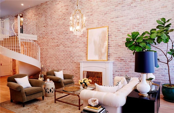 The two-story living room is striking not only for its soaring height but also for the custom spiral staircase and 20-foot reclaimed brick accent wall.