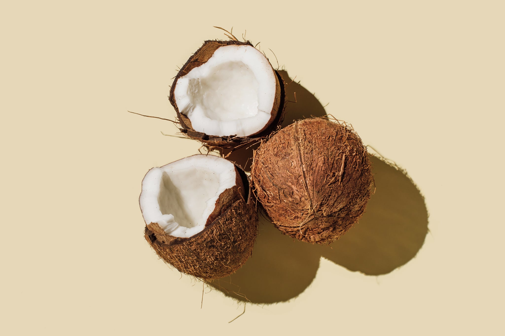 Ripe coconuts on beige background: is coconut oil good for you?