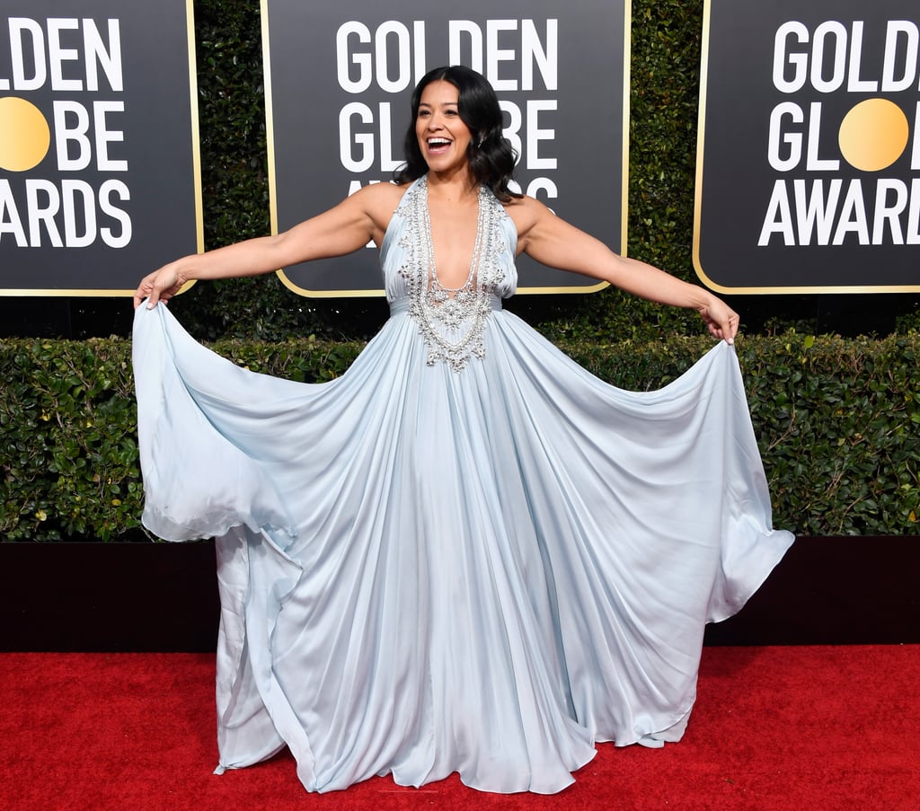 Gina Rodriquez wearing a Reem Acra dress that had a plunging neckline and Chopard jewels.