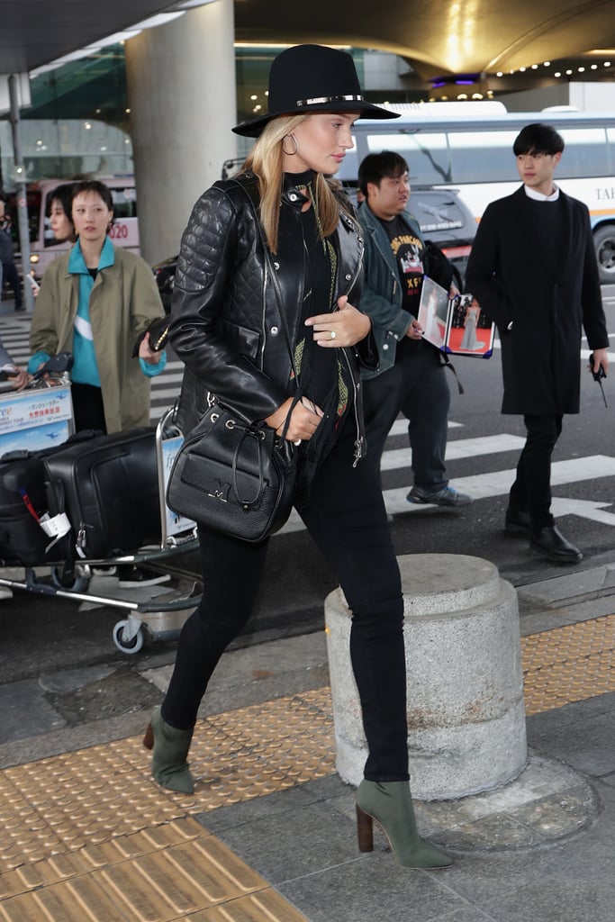 Rosie's airport style stays true to her bohomenian aesthetic. Here, she wore a leather jacket, skinny jeans, and green suede ankle boots. She topped off her ensemble with a black wide-brimmed hat and a fringed scarf by Rockins.