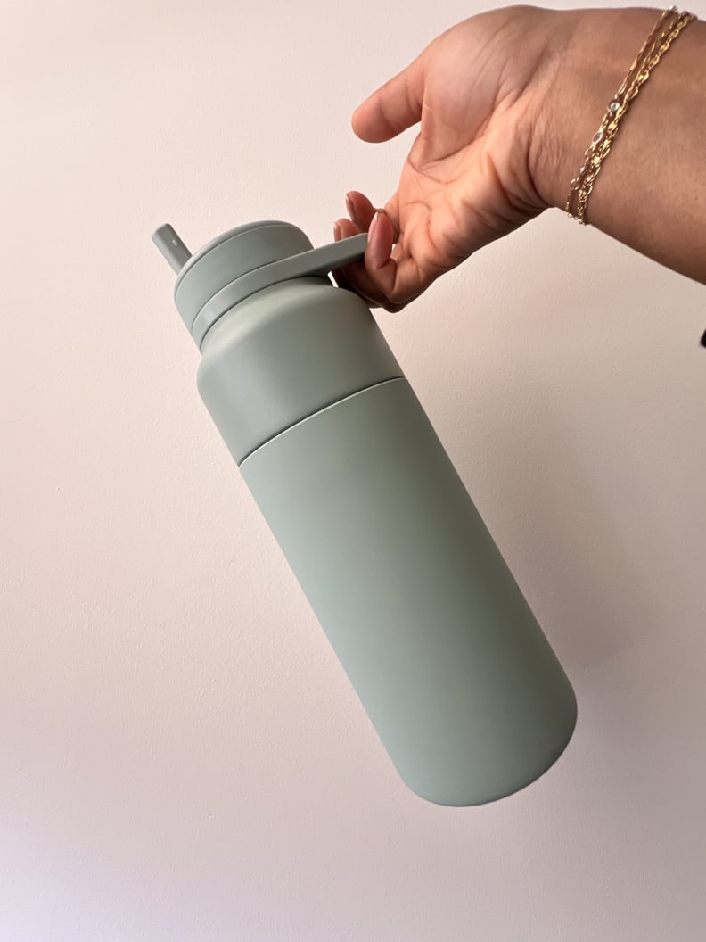 The Brümate Rotera water bottle held by the built-in handle.