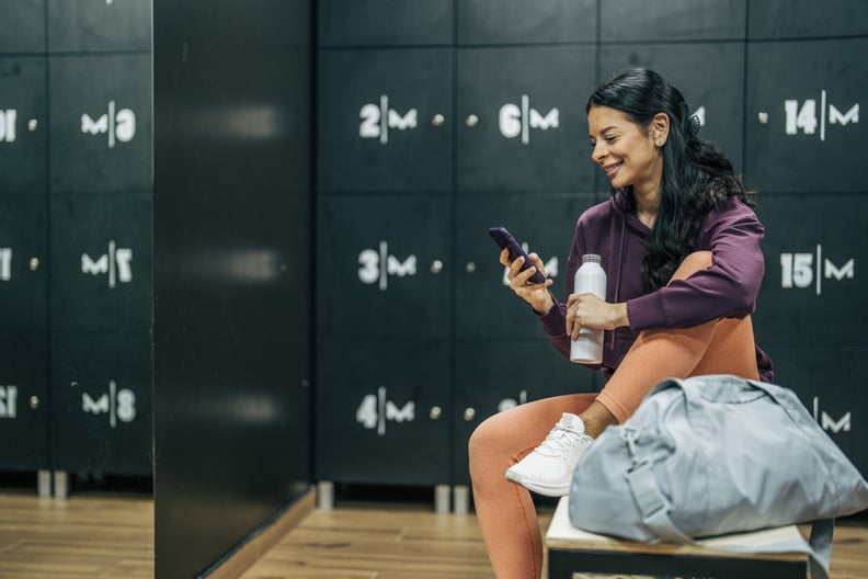Smiling sportswoman sitting in the locker room after training.