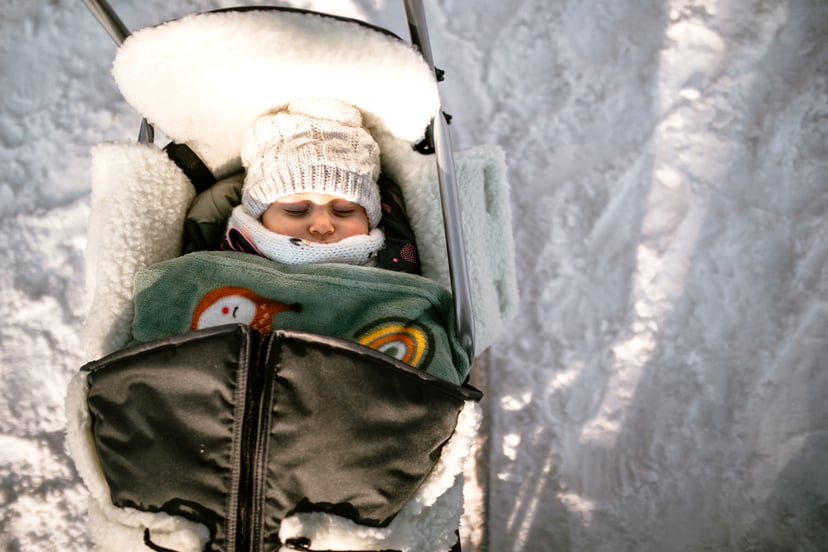 Baby girl sleeping in sled outdoor on winter day