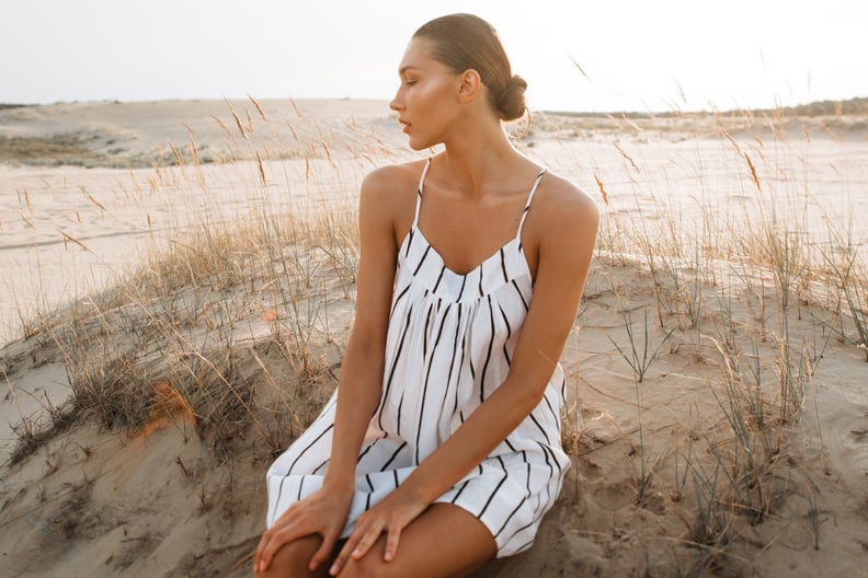 Girl in a striped dress in the evening desert. Model fashion in white dress on sand.; Shutterstock ID 1245789838; Job: -