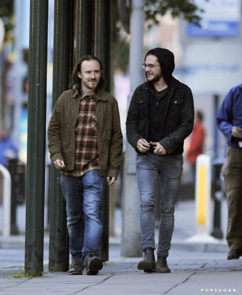 Is this good news for Game of Thrones fans?! Kit Harington, who plays Jon Snow on the series, was spotted in Belfast, Ireland — one of the show's filming locations — on Tuesday. The actor was all smiles, laughing alongside his Game of Thrones costar Ben Crompton, who plays Eddison Tollett. Although Kit's signature long locks were covered with his hood, he and his long hair did make an appearance at Wimbledon in early July.
Does this clear up the doubt over Jon Snow's death in the season five finale? Well, to be fair, if the character died, they'd possibly still need Kit to shoot a few scenes — maybe some sort of funeral or an extension of that heartbreaking final scene. In any case, keep reading to see more pictures of Kit Harington out and about in Northern Ireland, then find out how season five confirmed who Jon Snow's real parents are and check out theories about how Jon Snow will return to Game of Thrones.
