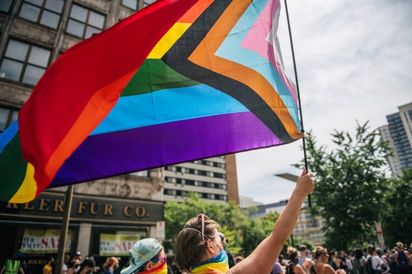 MINNEAPOLIS, MN - JUNE 28: A woman raises a flag during a Pride march on June 28, 2020 in Minneapolis, Minnesota. The demonstration was a call for justice, for George Floyd, and all victims of police murder. Demonstrators rallied to defend Black Trans liv